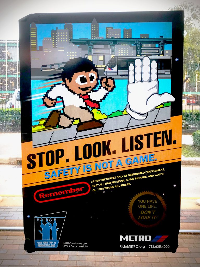 Stop, Look, Listen, retro game style advertising for safety at a Houston Bus Stop