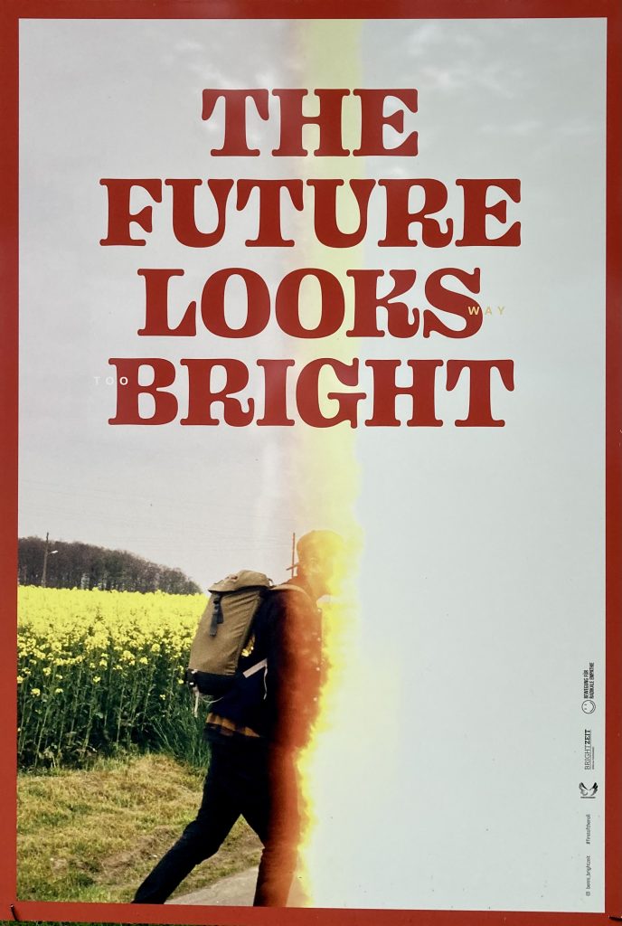 Does the future look bright? Or are we entering digital dark times? Image is a photo of a poster taken in Ravensburg, September 2021. The original image is from Benni Erbsland from the Erwegung fur Radikale Empathie (Movement for Radical Empathy) based out of Stuttgart: https://bewegung-fuer-radikale-empathie.de/benni-erbsland/